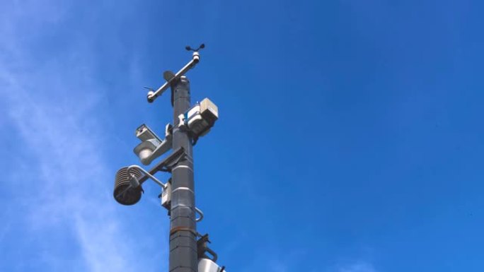 自动气象站，带有天气监测系统和用于观察的摄像机。在蓝天的背景下。