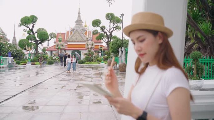 时髦的伦斯特女孩站在笔记本上涂鸦，游览黎明神庙。泰国的热门地点。