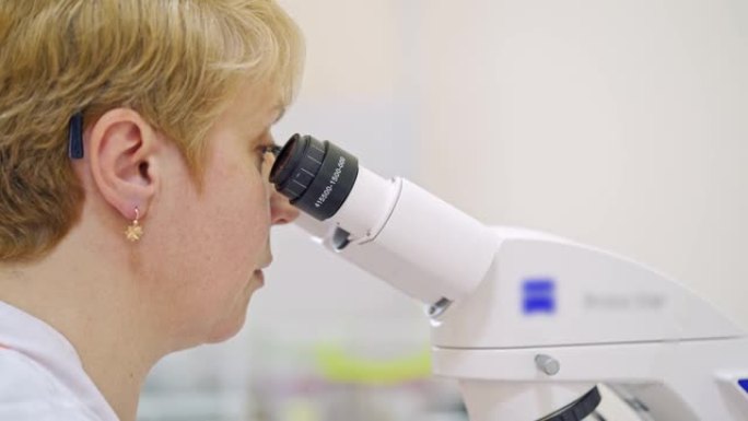 女科学家寻找显微镜目镜。