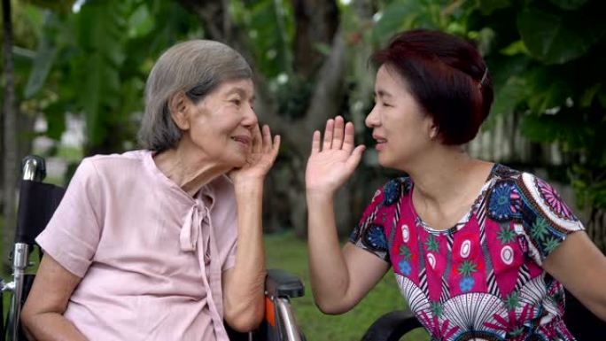 女儿与听力受损的老年妇女交谈