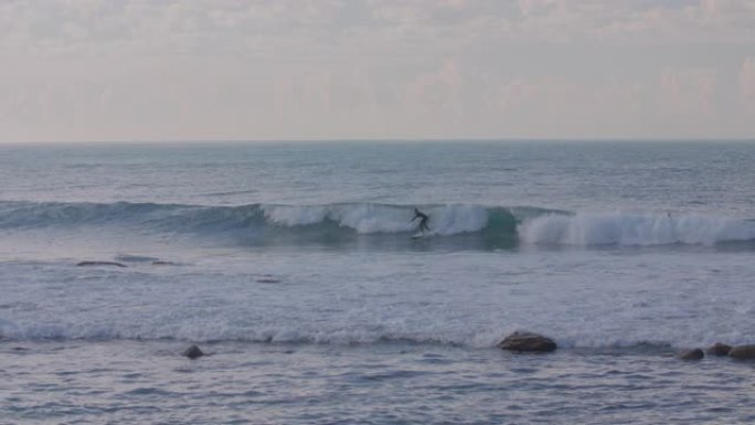 一名冲浪者设法在加利福尼亚州马里布 (malibu california) 赶上海浪，而另外两人则在