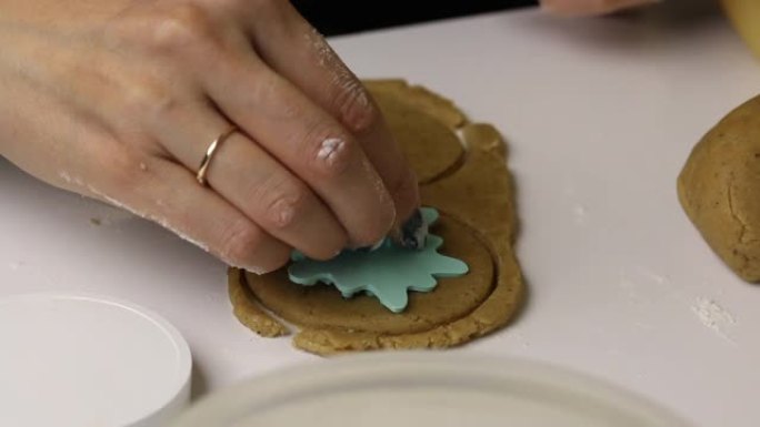 女人用邮票将图案贴在姜饼饼干空白上。