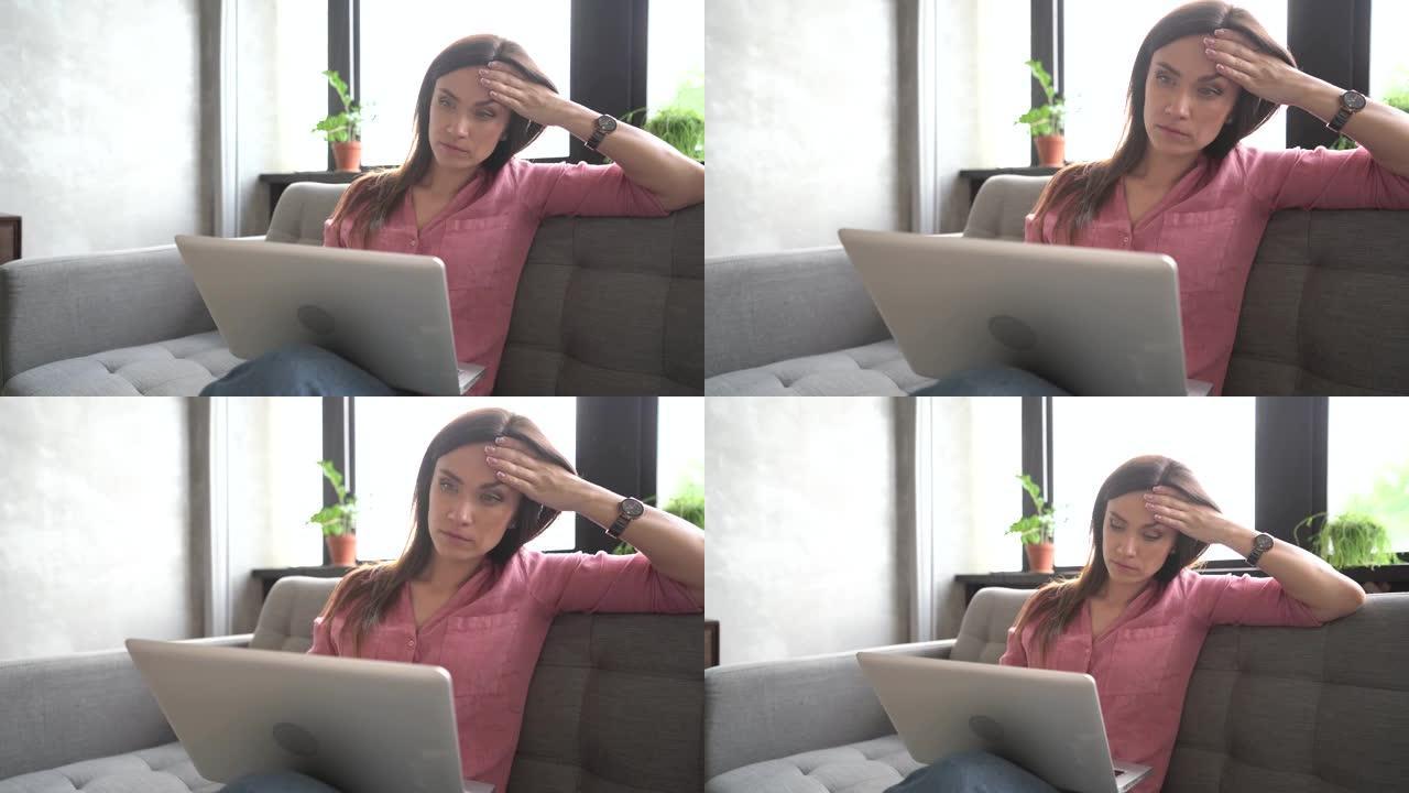 微笑的年轻女子坐在沙发上，用笔记本电脑笔记本看着屏幕打字信息，快乐的女士在电脑上聊天浏览浏览互联网社