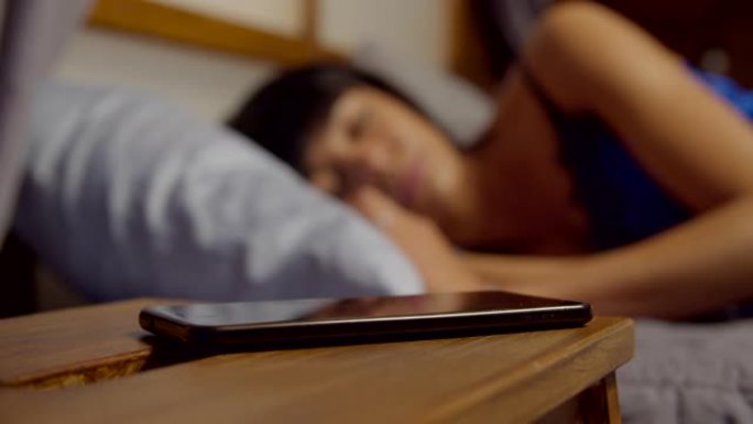 女人睡在床上被手机吵醒