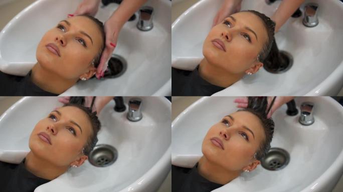 美发师将洗发水涂在女性湿头发上的特写