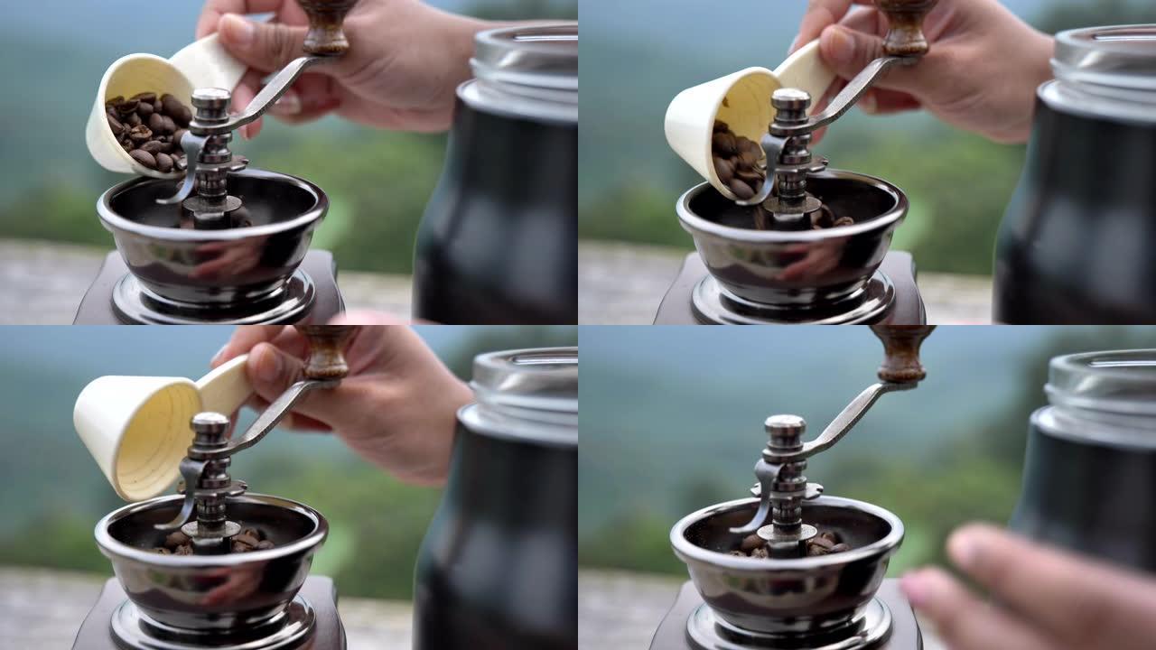 场景慢动作的人把咖啡豆放在手摇咖啡研磨机里，早上滴咖啡，咖啡时间