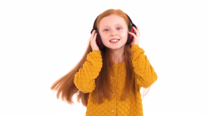 一个狡猾的小头发模特的肖像照片在无线耳机和舞蹈中享受音乐。真实的情感。孤立，在白色背景上