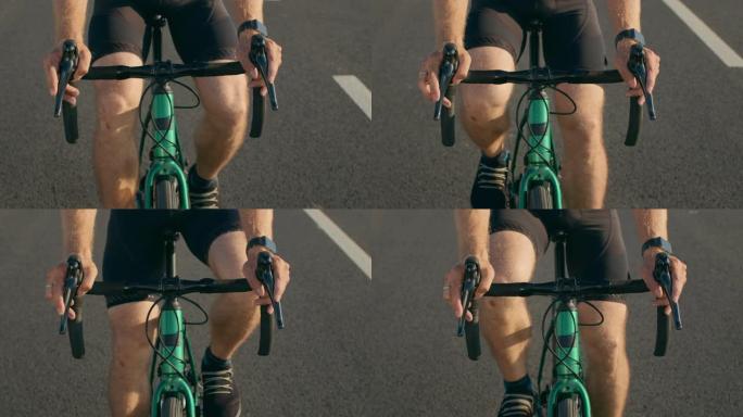 自行车手在方向盘上的特写镜头。他猛踩刹车，踩踏板。骑自行车训练。4K