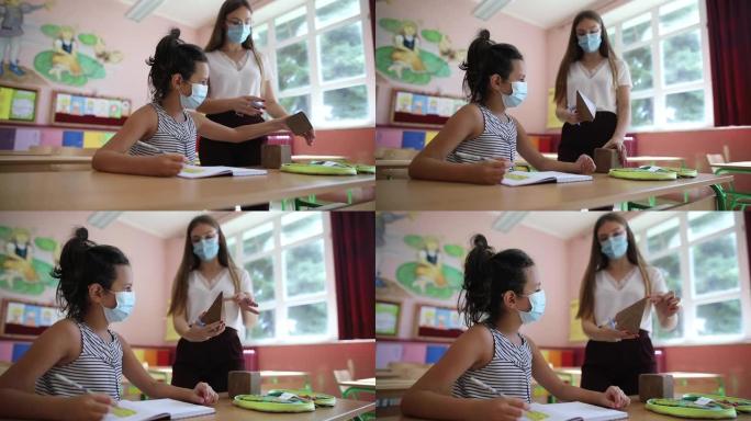 新型冠状病毒肺炎大流行期间，老师和女孩戴着防护口罩上课