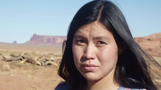 纪念碑谷印第安人保留地亚利桑那州北部沙漠中一位美丽的纳瓦霍印第安人印第安女孩的户外肖像
