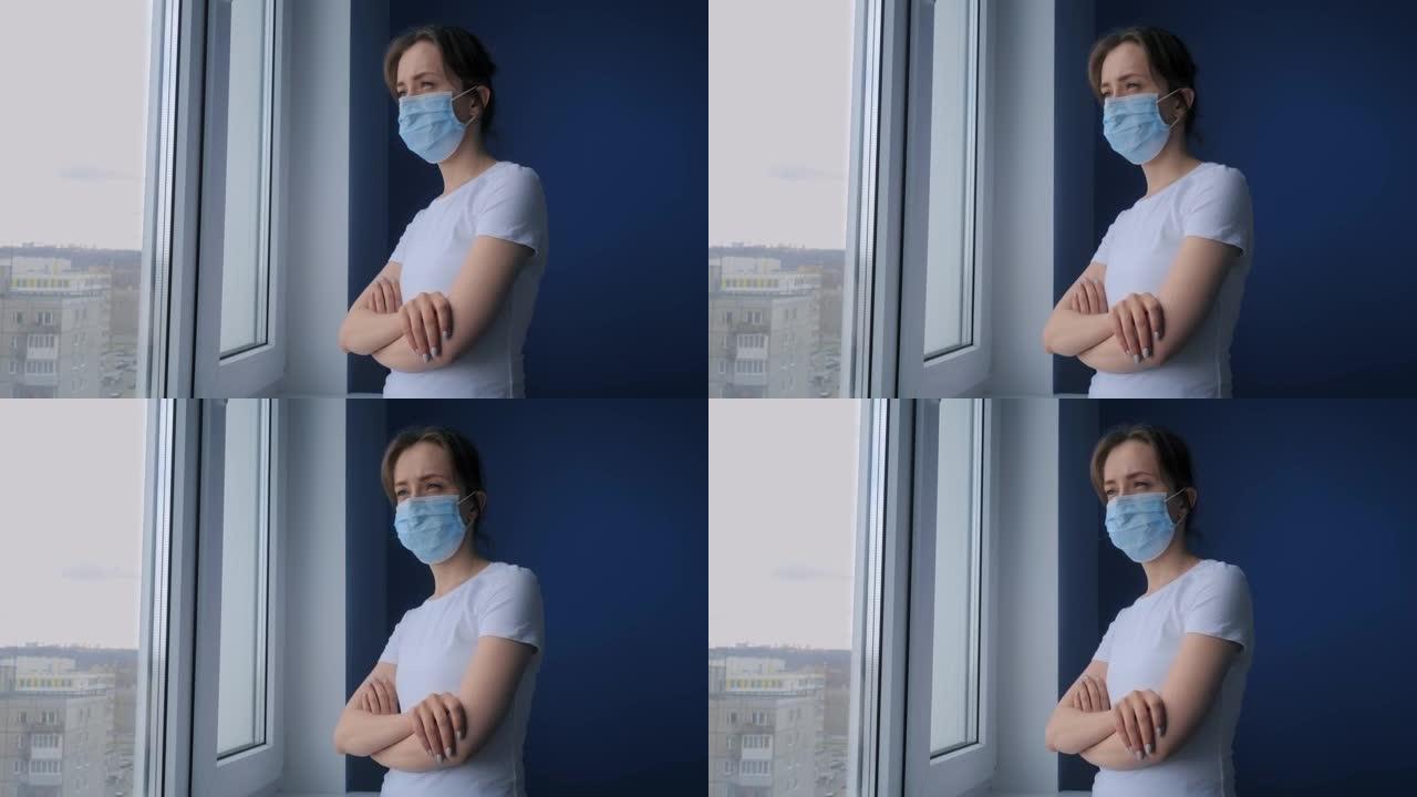 慢动作: 戴着医用口罩并向窗外看的沉思妇女