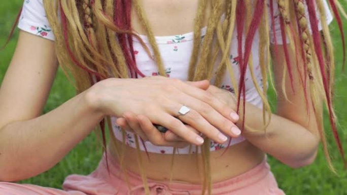 女孩长发锁发型手握小天然石头玫瑰夸兹，水钻，天使石，anyolite和azurite，脸不可见