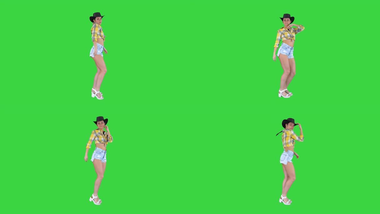 年轻的女牛仔在绿色屏幕上跳舞，色键