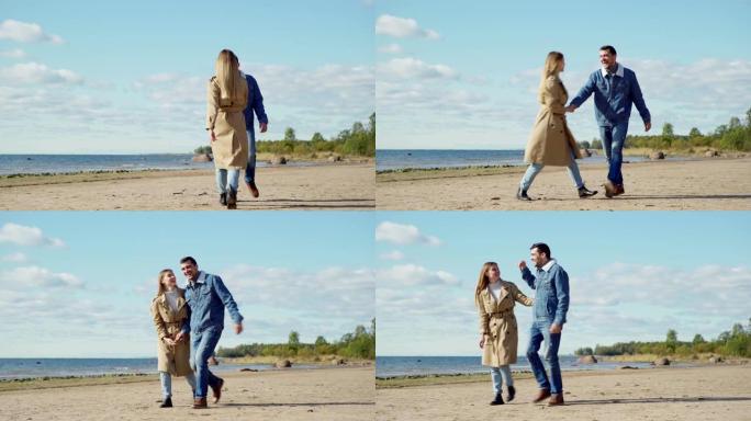 顽皮的年轻夫妇在春天的日子里在海边散步，热情拥抱，全长宽镜头