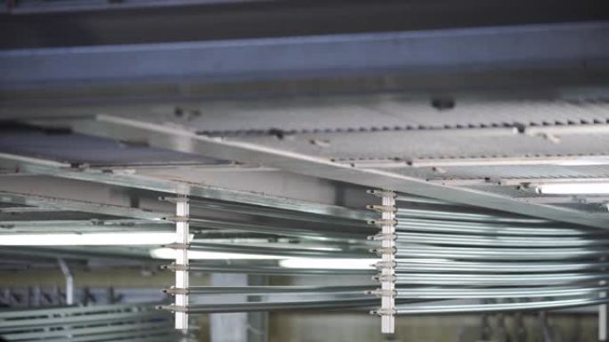阳极氧化。企业中铝的阳极氧化工艺铝型材与帮助梁起重机一起浸入特殊解决方案中。金属加工。
