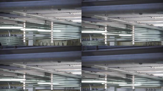 阳极氧化。企业中铝的阳极氧化工艺铝型材与帮助梁起重机一起浸入特殊解决方案中。金属加工。