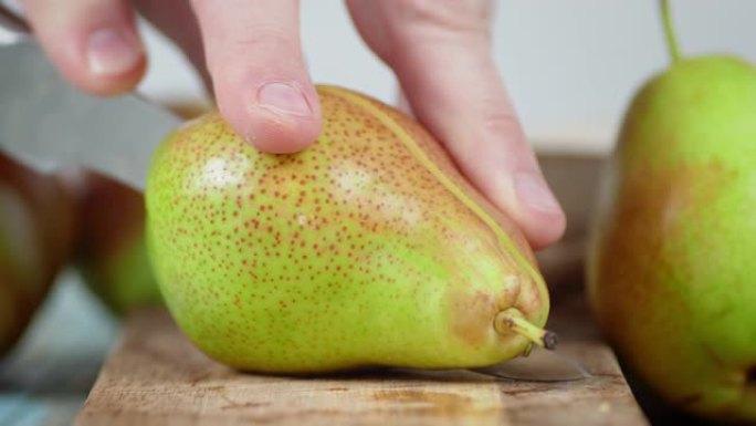 男人把一个成熟的梨切成两半。