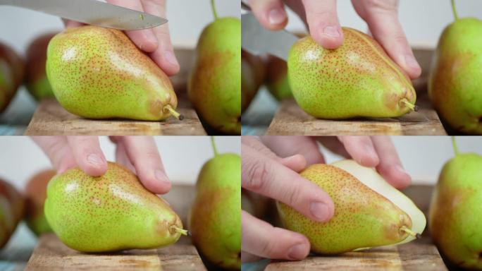 男人把一个成熟的梨切成两半。