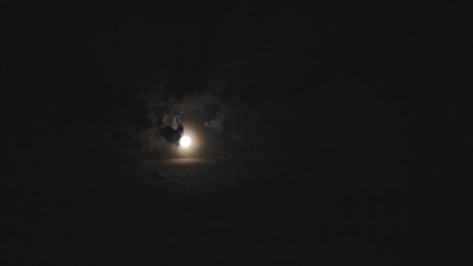 月亮在黑色多云的天空中闪耀怪异的月景气氛
