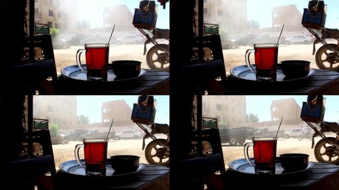 埃及巴哈里亚绿洲，在柔和的背景上，一杯带自行车和人们的贝都因人的茶的细节