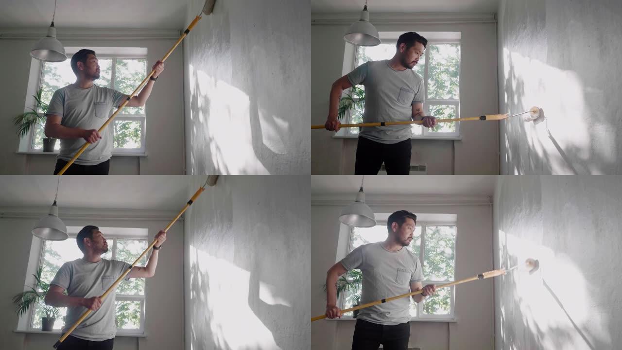 日本男子用油漆滚筒在家里粉刷墙壁