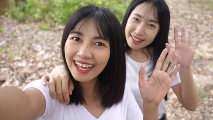 两名年轻的微笑亚洲妇女在森林中旅行