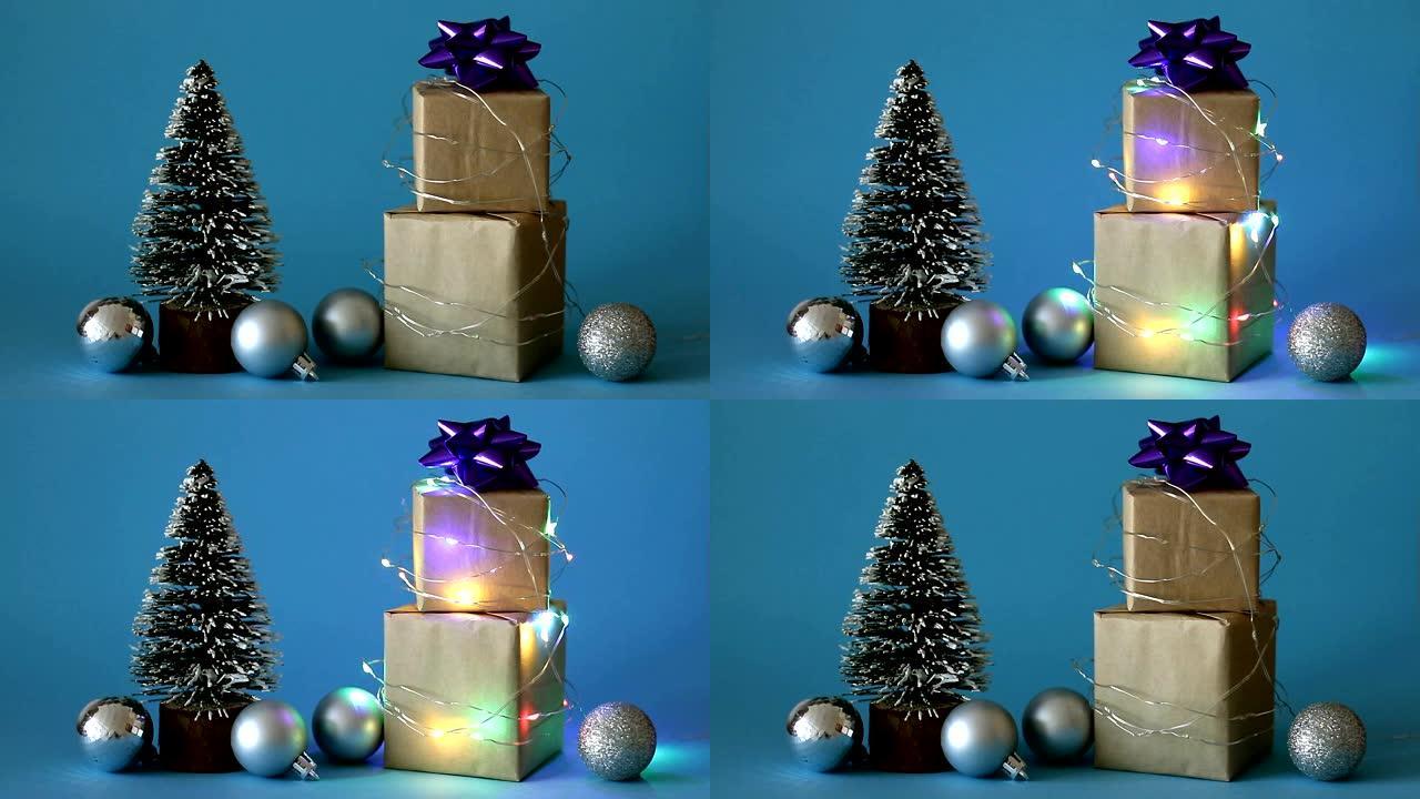 圣诞礼品盒包裹在闪烁的花环中，带有圣诞树和蓝色背景上的玩具。圣诞快乐!假日概念