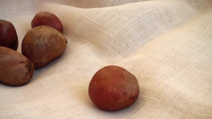 土豆落在粗麻布上。慢动作。