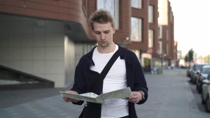 年轻人游客带着地图在城市里找到路