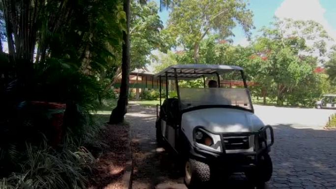 在酒店内散步并在热带茂密的小路上乘坐高尔夫球车