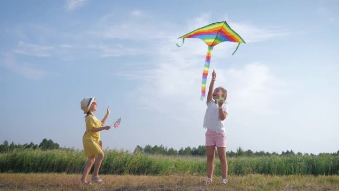 女孩玩风筝，小快乐的女朋友在暑假期间在森林林间空地上玩空气玩具