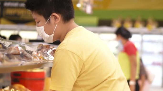 亚洲儿童在超市购物，在新型冠状病毒肺炎期间囤积食物，生活方式概念。
