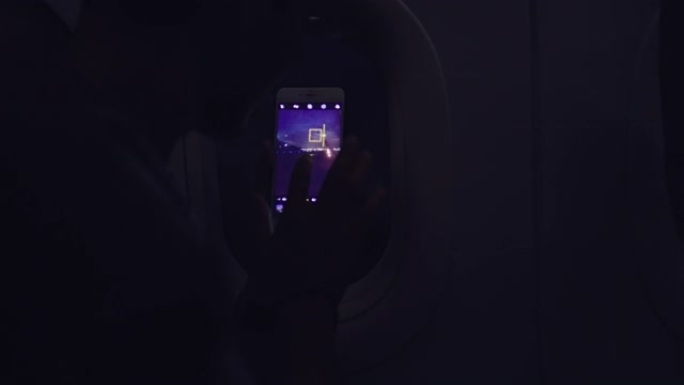 亚洲男子在飞机上使用智能手机