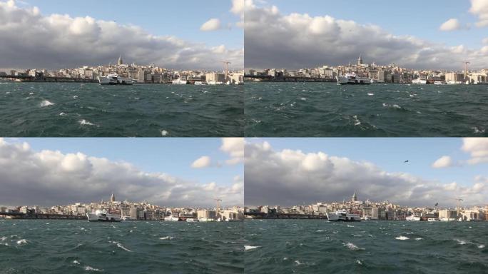 加拉塔的慢动作拍摄，在前景游船上与游客和海鸥。加拉塔塔背景上的游船，多风的天气