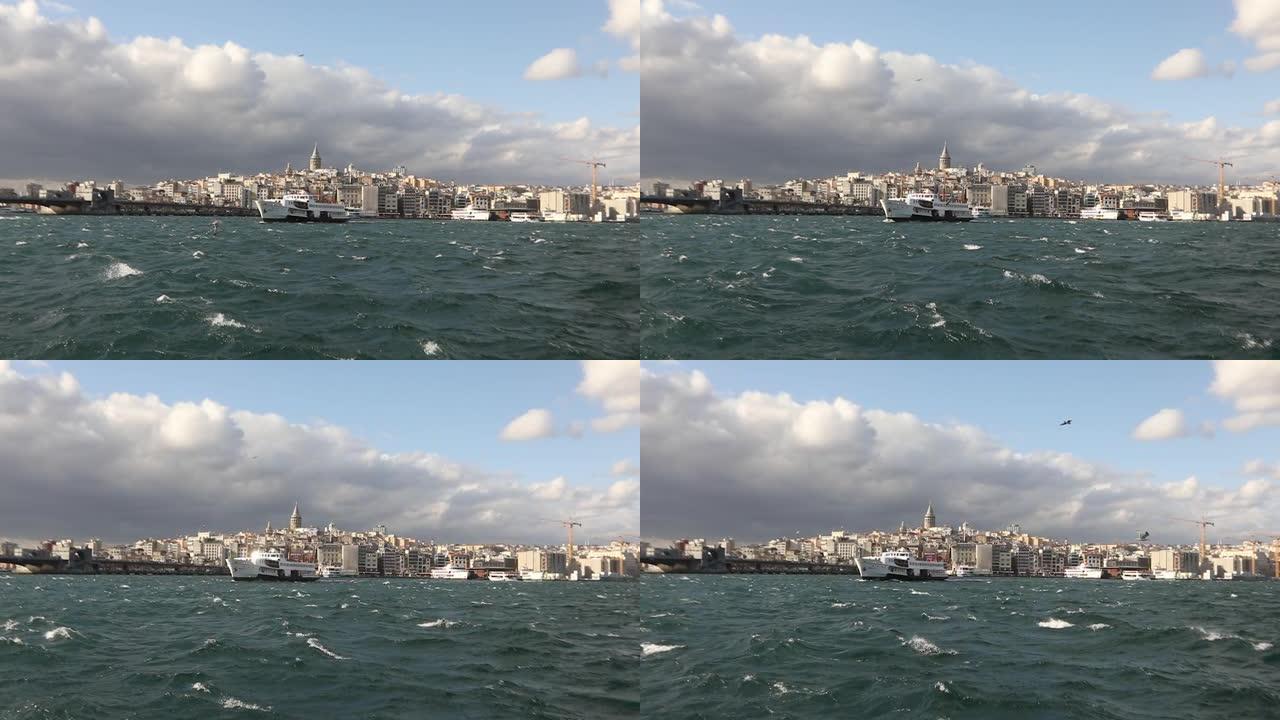 加拉塔的慢动作拍摄，在前景游船上与游客和海鸥。加拉塔塔背景上的游船，多风的天气