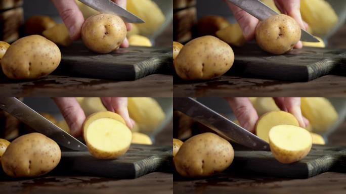 男人的手切成两半，去皮的土豆。