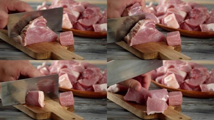 男人的手用刀切成烤肉串的生猪肉。