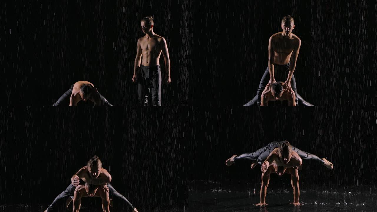 两个男杂技演员在雨中倒立。协调良好的团队合作。在黑色背景上拍摄，慢动作照明。特写