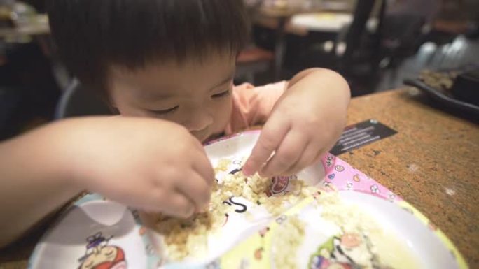 一个小男孩在餐厅独自吃米饭