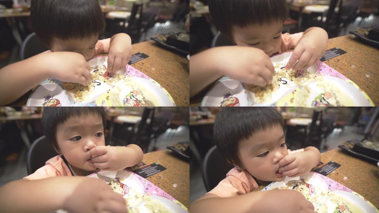 一个小男孩在餐厅独自吃米饭