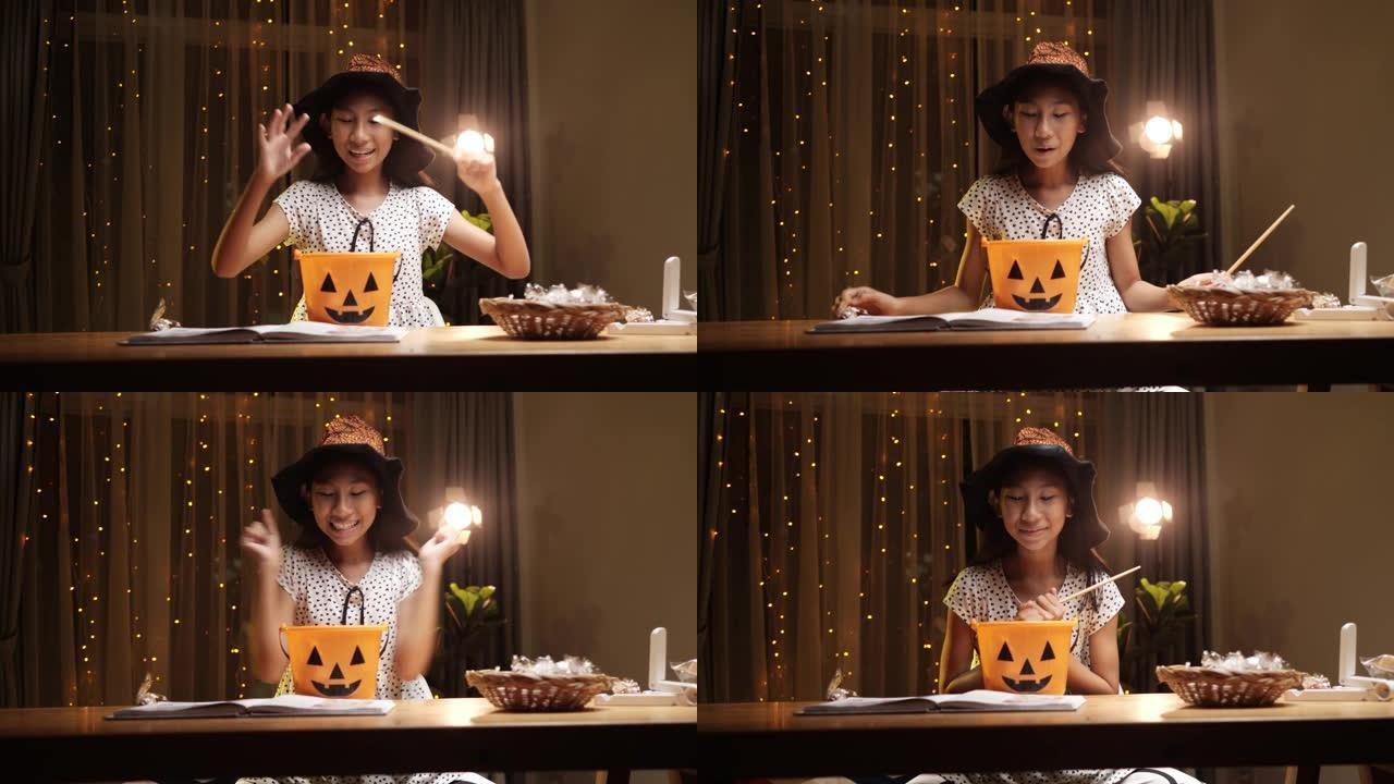 戴着魔杖的女巫帽子的亚洲女孩在晚上在家玩万圣节概念。