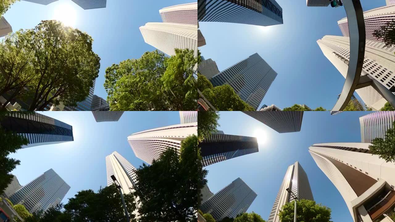 开车穿过城市的摩天大楼。扭转并仰望摩天大楼和绿树的景色。
