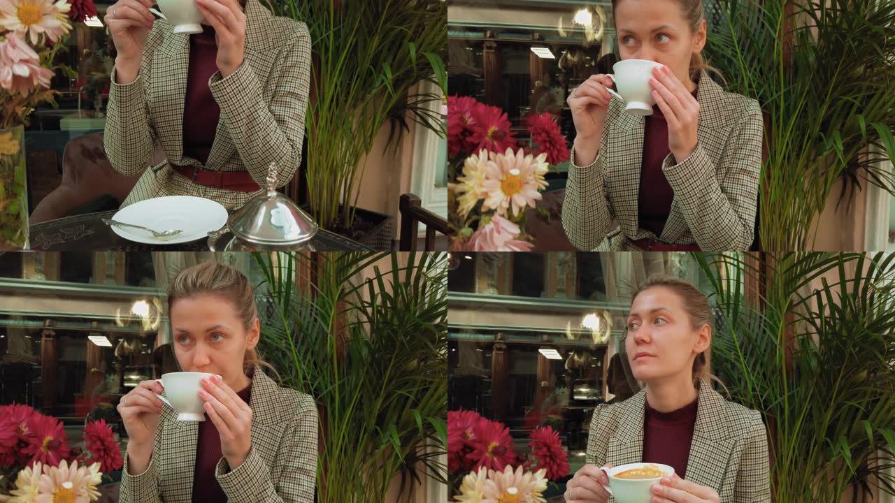 一名年轻女子在巴黎的一家复古餐厅喝咖啡。复古风格的咖啡馆，配有充满活力的花朵和复古家具