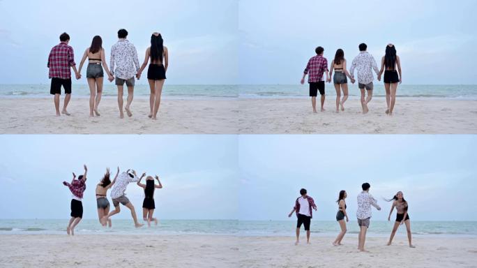 年轻的亚洲朋友与在沙滩上跳跃