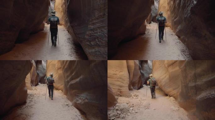 运动旅游男子在深槽峡谷干燥的河床上徒步旅行，橙色岩石