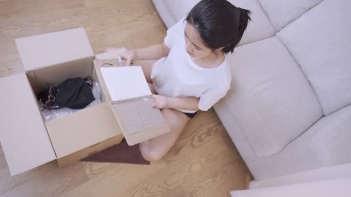 成年亚洲妇女打开储物箱的东西整理，客厅内，搬迁搬进新公寓