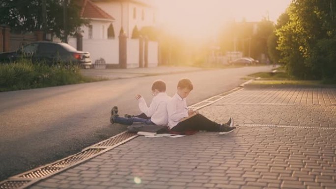 男生坐在被书本包围的街道人行道上