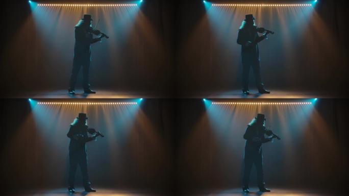 一位经验丰富的小提琴家在舞台上表演了令人惊叹的独奏，在黑色背景下的灯光下可以看到。一个穿着黑色西装和