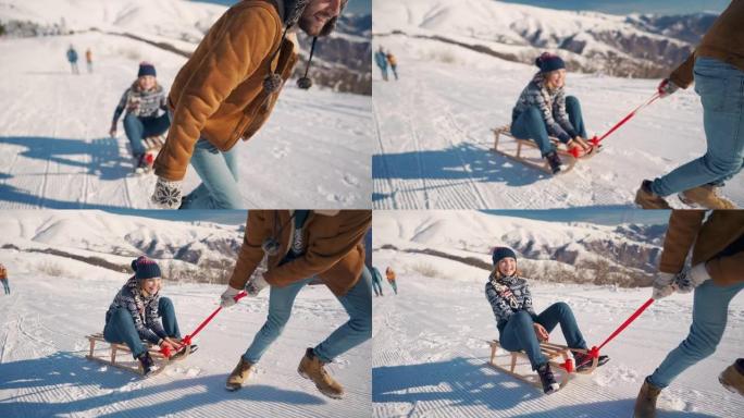 年轻的家伙把他的女朋友拉到山上的雪橇上，而她却在享受和大笑