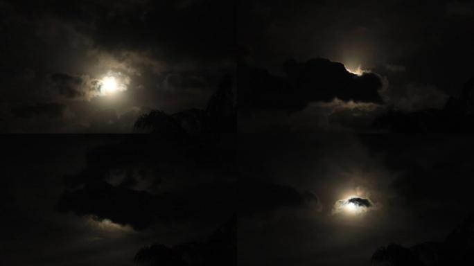 明亮的黄色月亮光在黑色和灰色的云层中发光的夜景视图